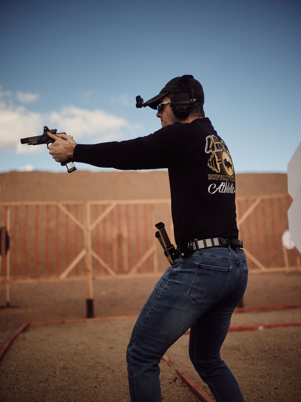 Shooter engaging targets at a USPSA match